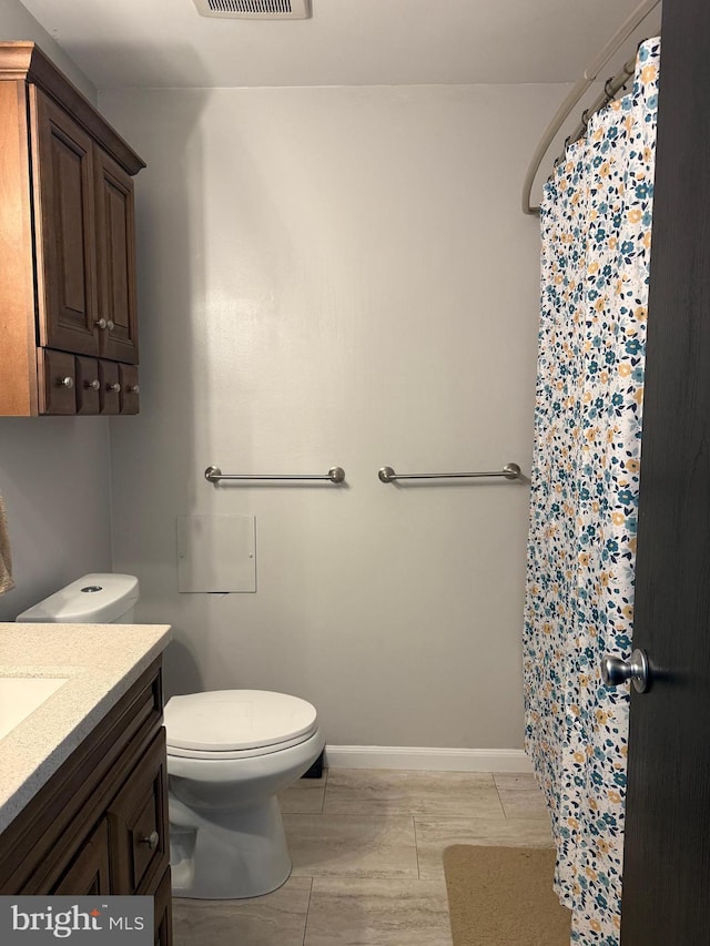 bathroom featuring vanity, curtained shower, and toilet