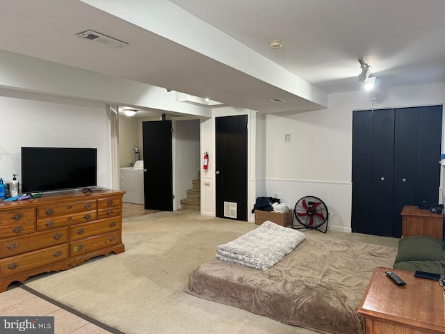 carpeted bedroom featuring washing machine and dryer and wooden walls