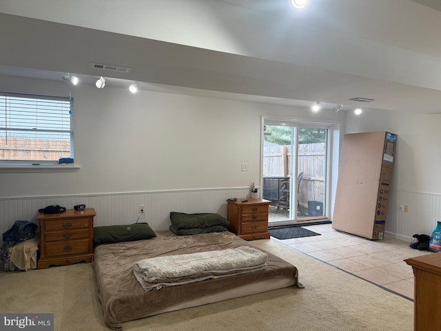 bedroom featuring light tile patterned floors, access to outside, and wooden walls