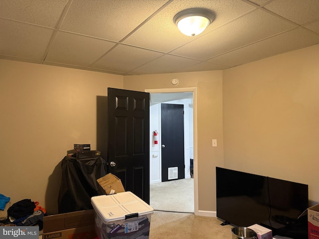 carpeted office featuring a paneled ceiling