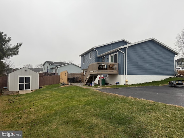 rear view of property with a yard, central AC unit, a shed, and a deck