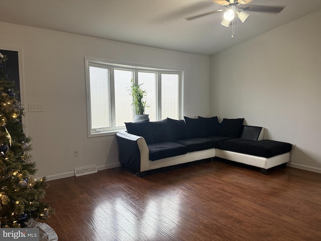 living room with ceiling fan and dark wood-type flooring