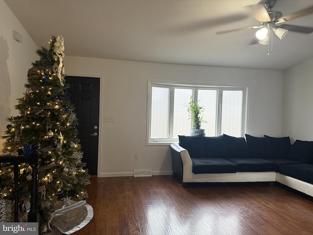 living room featuring ceiling fan and dark wood-type flooring