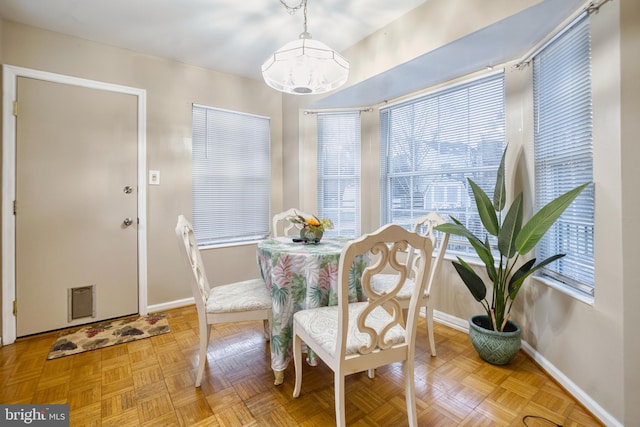 dining area with an inviting chandelier and light parquet flooring