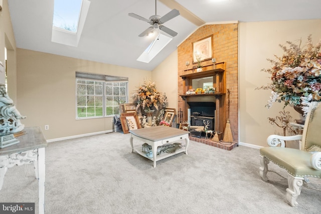 carpeted living room with ceiling fan and vaulted ceiling with skylight