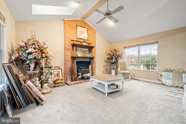 living room with carpet flooring, lofted ceiling with skylight, and ceiling fan