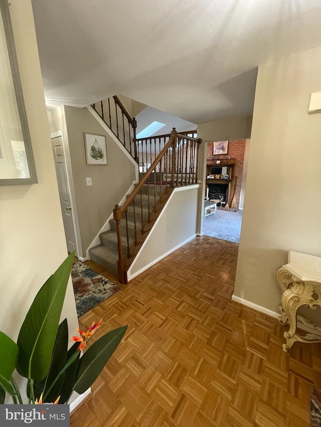 stairway featuring parquet floors and a fireplace