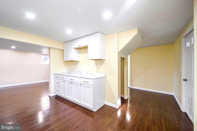 kitchen with dark hardwood / wood-style floors and white cabinetry