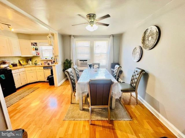 dining room with ceiling fan, cooling unit, and light hardwood / wood-style floors