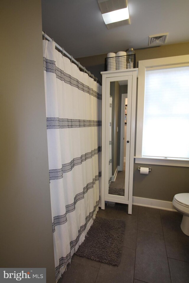 bathroom with toilet and tile patterned floors