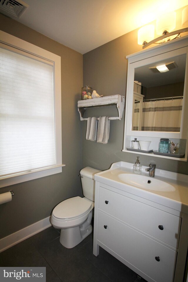 bathroom with tile patterned flooring, vanity, and toilet