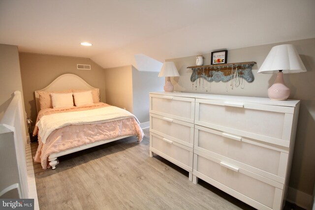 bedroom featuring lofted ceiling and light hardwood / wood-style flooring