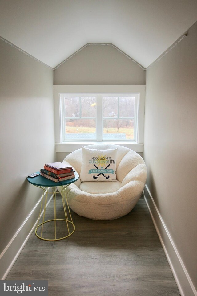 living area with hardwood / wood-style flooring, a healthy amount of sunlight, and vaulted ceiling