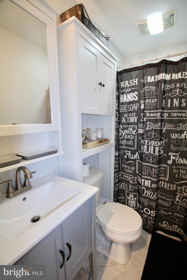 bathroom featuring a shower with curtain, vanity, and toilet