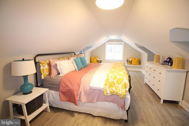 bedroom featuring lofted ceiling and light hardwood / wood-style flooring