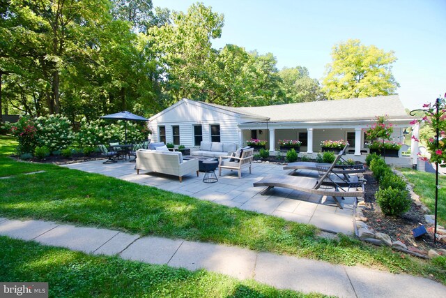 back of property featuring an outdoor living space and a patio