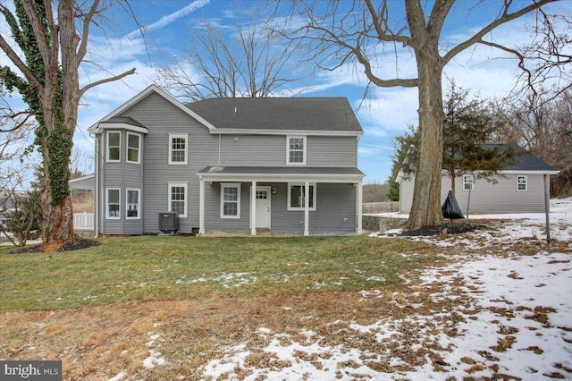 snow covered rear of property with a yard and central air condition unit