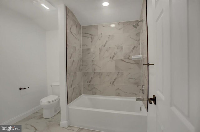 bathroom featuring tiled shower / bath combo and toilet