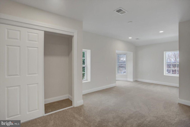 unfurnished bedroom featuring a closet and light colored carpet