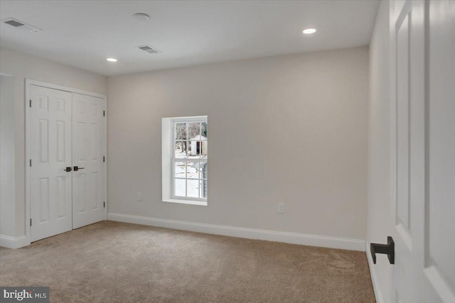 unfurnished bedroom featuring a closet and light carpet