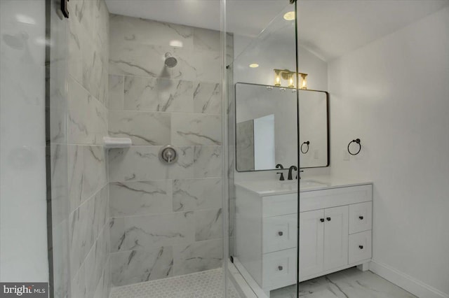 bathroom with tiled shower and vanity