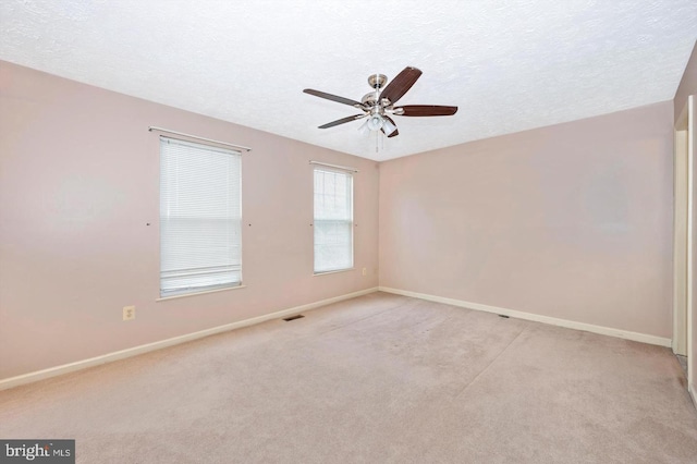 carpeted spare room with ceiling fan and a textured ceiling