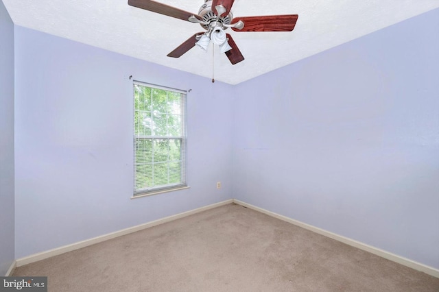 carpeted empty room featuring ceiling fan and a textured ceiling