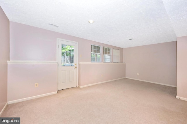 carpeted empty room featuring a textured ceiling