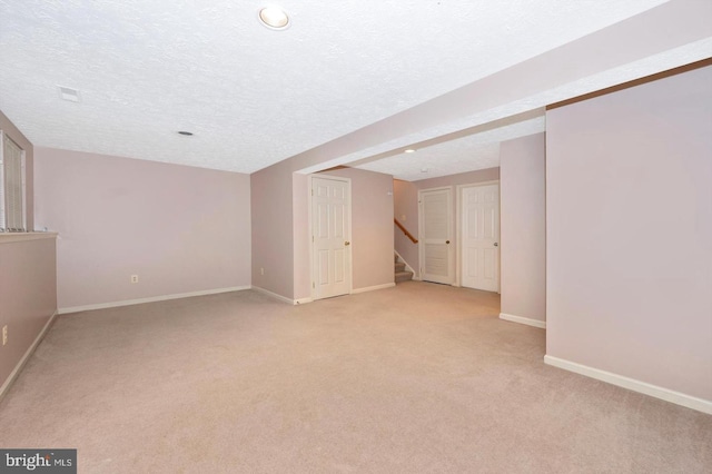 basement with light carpet and a textured ceiling