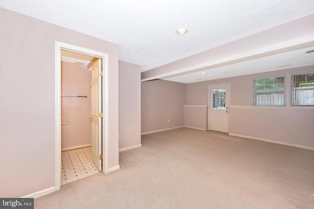 basement with a textured ceiling and light carpet