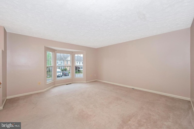 carpeted spare room with a textured ceiling