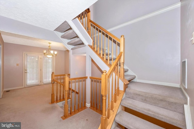 stairway featuring a chandelier and carpet flooring