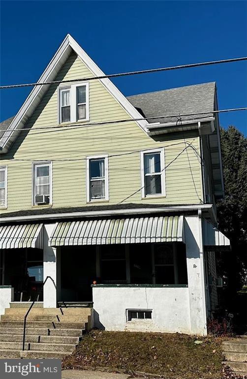 view of front facade with covered porch and cooling unit