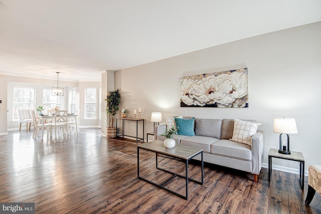 living room with dark hardwood / wood-style flooring and a notable chandelier