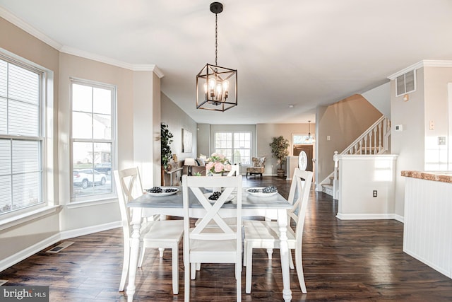 dining area with dark hardwood / wood-style flooring, ornamental molding, and a chandelier