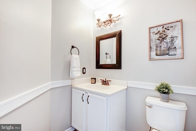 bathroom featuring vanity, toilet, and crown molding