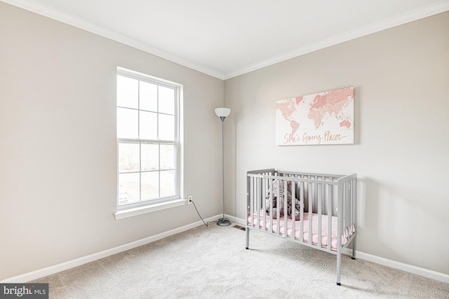 bedroom featuring crown molding, a crib, and carpet floors