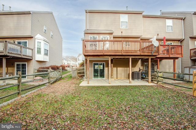 back of house featuring a lawn, cooling unit, a patio, and a wooden deck