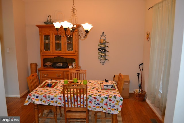 dining space with a chandelier and dark hardwood / wood-style floors