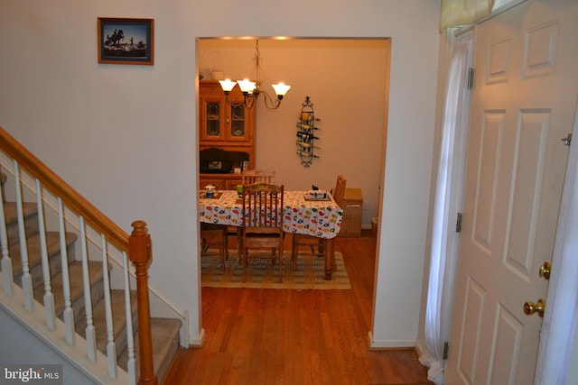 hallway featuring hardwood / wood-style floors and a notable chandelier