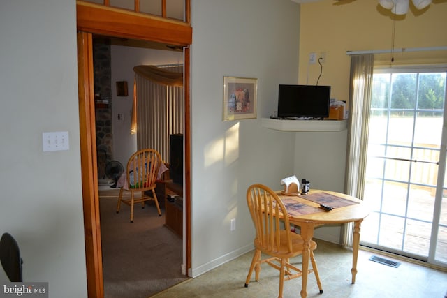 dining area featuring light carpet and ceiling fan