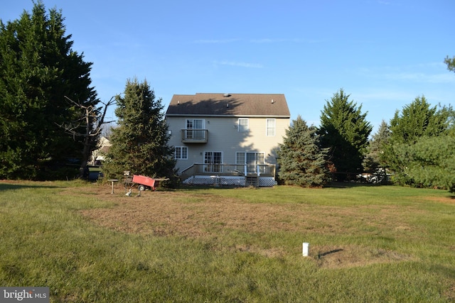 back of house with a yard, a balcony, and a deck