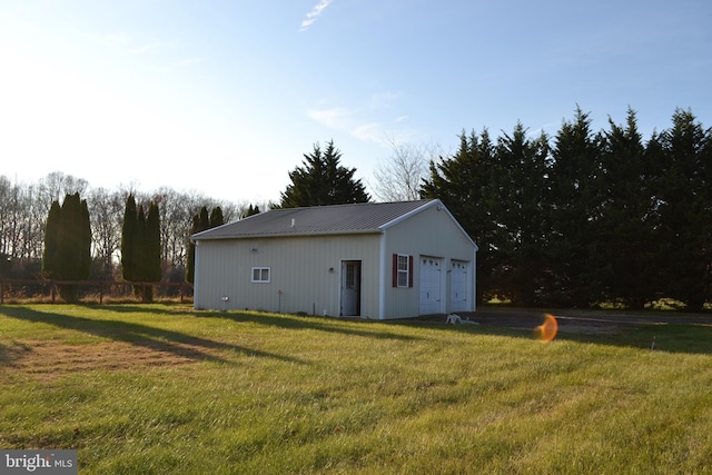 view of outdoor structure with a lawn and a garage