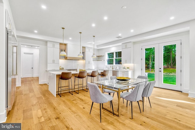 dining area featuring french doors and light hardwood / wood-style floors