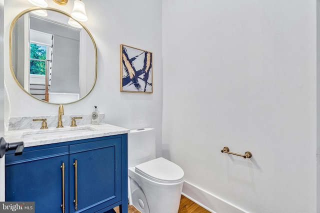 bathroom featuring toilet, vanity, and hardwood / wood-style flooring