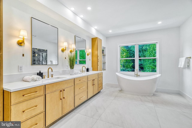 bathroom with tile patterned flooring, vanity, and a bath