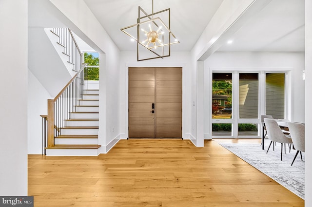 foyer entrance with an inviting chandelier and light wood-type flooring