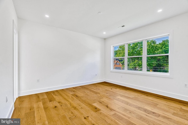 empty room with light hardwood / wood-style flooring