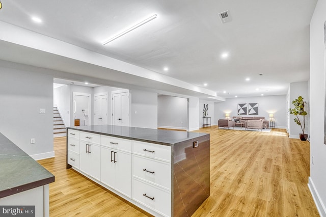 kitchen featuring a center island, light hardwood / wood-style flooring, and white cabinetry