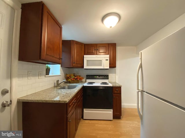 kitchen with decorative backsplash, sink, white appliances, and light wood-type flooring